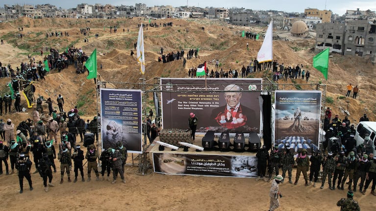 A drone view shows Palestinian militants gathering near the coffins during the handover of deceased hostages Oded Lifschitz, Shiri Bibas and her two children Kfir and Ariel Bibas, seized during the deadly October 7, 2023 attack, to the Red Cross, as part of a ceasefire and hostages-prisoners swap deal between Hamas and Israel, in Khan Younis in the southern Gaza Strip, February 20, 2025. REUTERS/Stringer