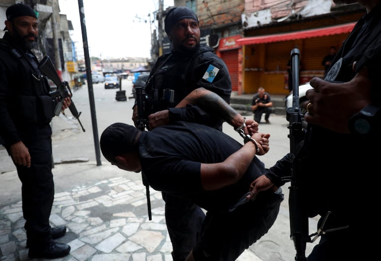 A man is detained by police officers during a police operation against drug trafficking at the favela do Penha, in Rio de Janeiro, Brazil October 28, 2025. REUTERS/Aline Massuca