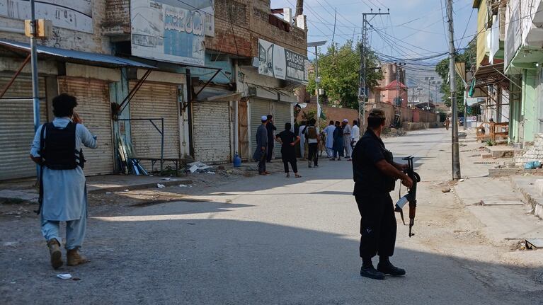 Agentes de policía custodian una carretera cerca de donde se produjo una potente explosión en una mezquita en Kohat, Pakistán. (AP Foto/B.S. Gillani)