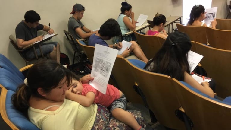 Alicia completó su examen con su beba dormida en brazos.