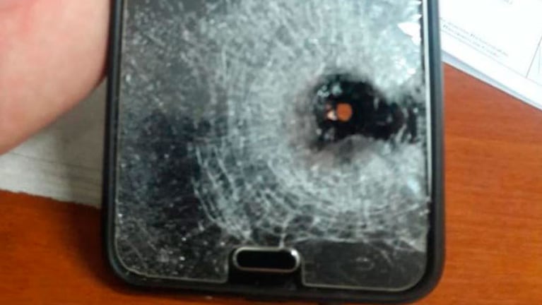 Así quedó la pantalla del celular tras el impacto de bala.