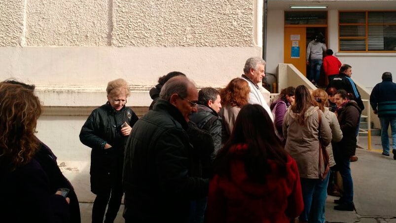 Bajo el frío de la mañana, la gente esperó que los empleados levanten las medidas de fuerza.