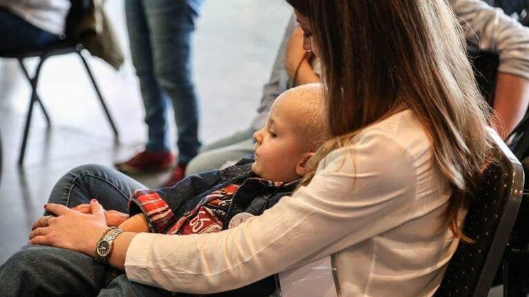 Beni en brazos de su mamá Ivana. Necesita ayuda para conseguir su silla motorizada.