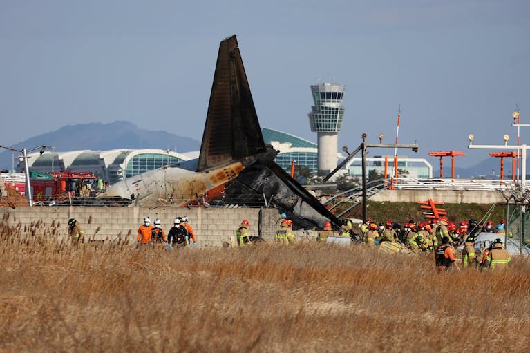 Bomberos y socorristas trabajan en el Aeropuerto Internacional de Muan, en Corea del Sur, el domingo 29 de diciembre de 2024, luego de que un avión comercial se salió de la pista de aterrizaje, chocó contra un muro de concreto y se incendió. (Cho Nam-soo/Yonhap via AP)