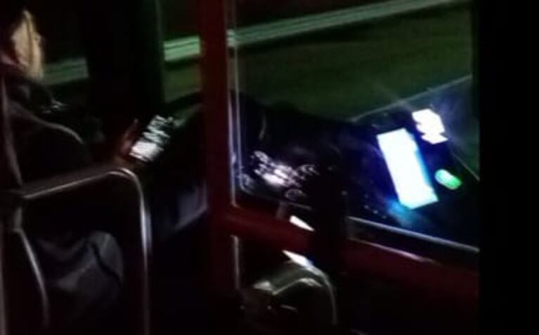 Colectivero manejando con un celu en una ruta de Córdoba.