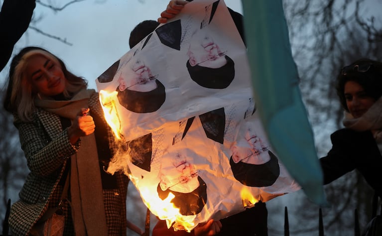 Demonstrators burn pictures of Iran's Supreme Leader Ayatollah Ali Khamenei outside the Iranian embassy during a rally in support of nationwide protests in Iran, in London, Britain, January 12, 2026. REUTERS/Toby Melville