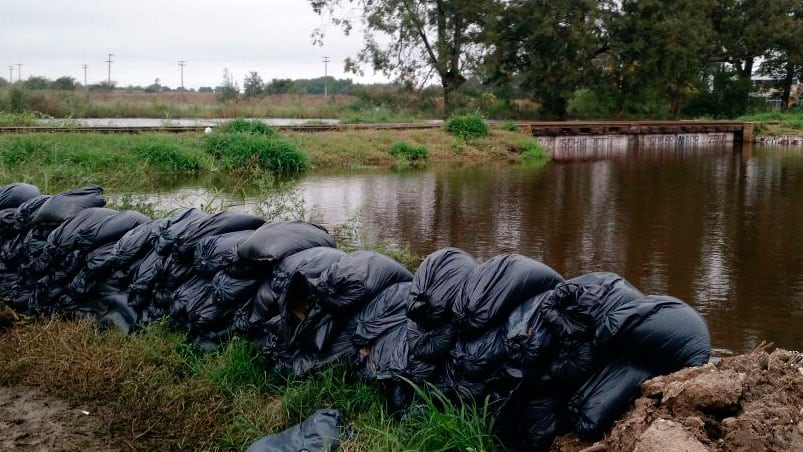 ¡Desesperación! En Arroyito rompieron el asfalto para desviar el agua que está entrando a la ciudad.