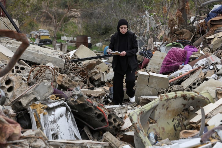 Displaced Lebanese Assaad Bzih's daughter, Zeinab, walks on rubble near her destroyed home, after a ceasefire between Israel and Hezbollah took effect, in Zibqin southern Lebanon, November 27, 2024. REUTERS/Aziz Taher