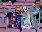 Dos hinchas con distintas camisetas pero unidos en la tribuna. 