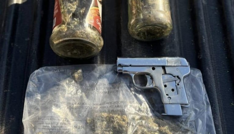 El arma y los frascos de marihuana que secuestró la Policía.