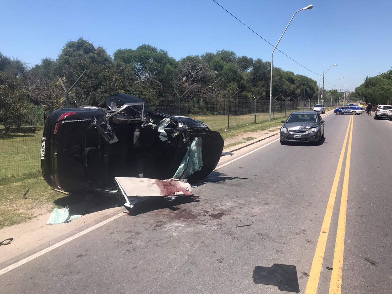 El auto policial volcó y quedó destruido.