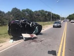 El auto policial volcó y quedó destruido.