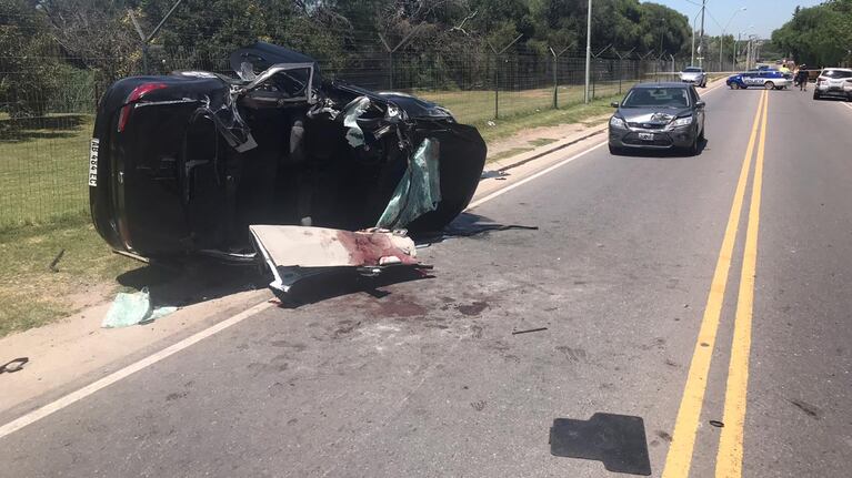 El auto policial volcó y quedó destruido.