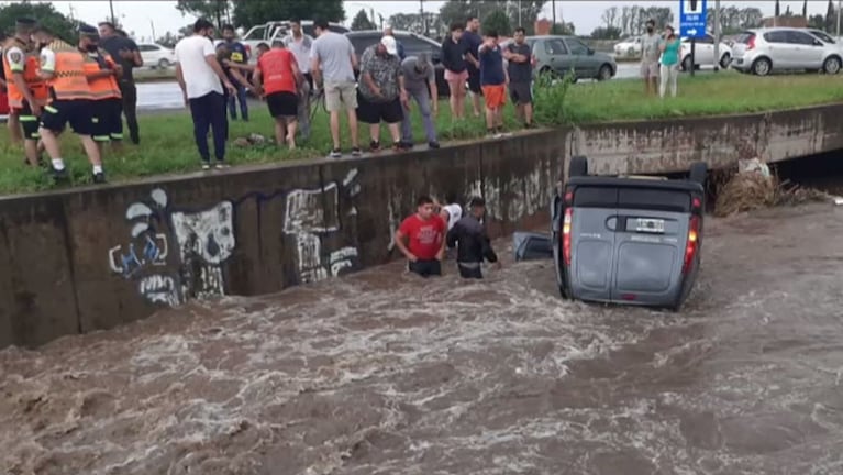 El auto quedó dado vuelta en el canal cargado de agua.