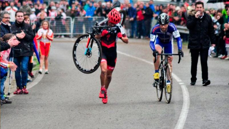 El ciclista, cansado, corriendo con la bici al hombro. Su rival nunca lo pasó.