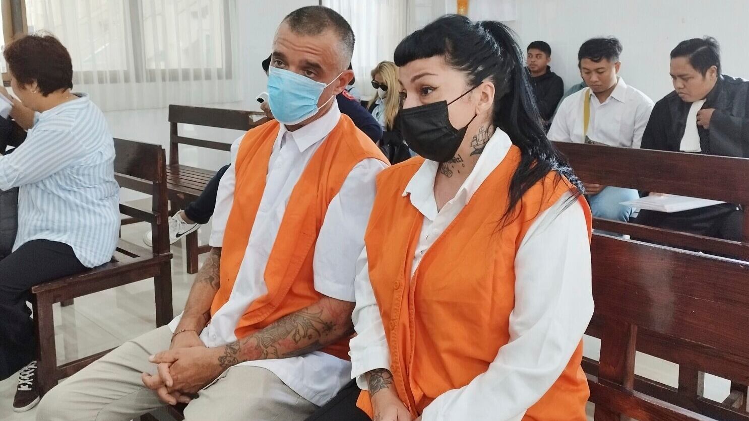 El ciudadano británico Elliot James Shaw, a la izquierda, y la ciudadana argentina Eleonora Gracia, a la derecha, que están acusados de llevar cocaína de contrabando a Indonesia, se sientan en la banca de los acusados al inicio de su juicio en Denpasar, Bali, el jueves 26 de junio de 2025. (AP Foto)