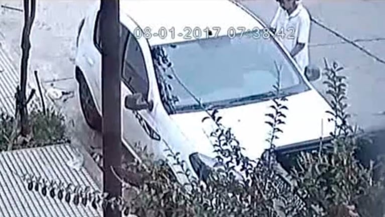 El delincuente intenta abrir la puerta del auto de un vecino.