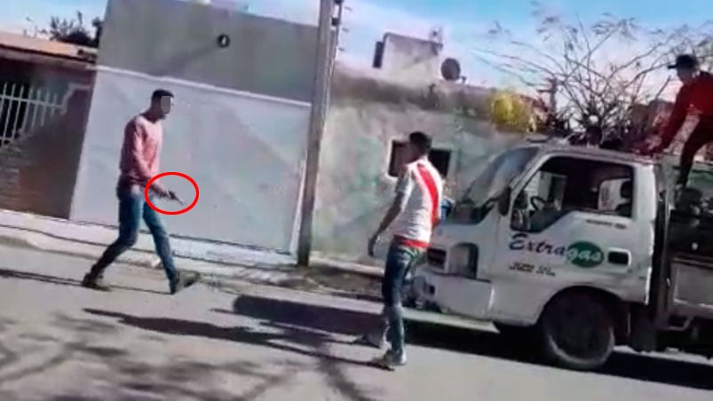 El distribuidor, con el arma en su mano y frente al joven a quien luego le disparó.