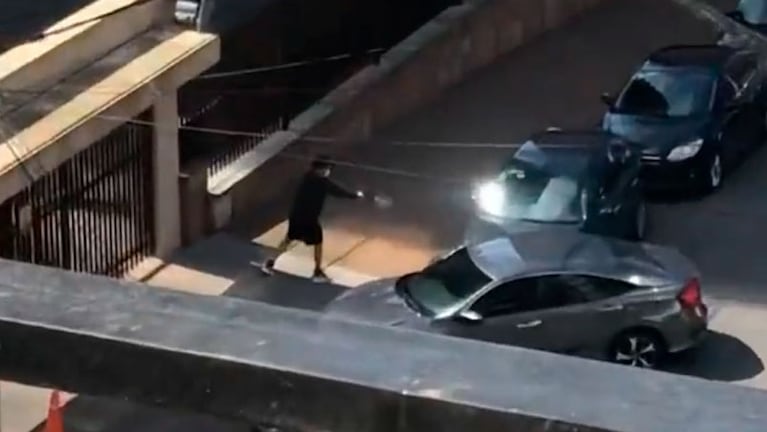 El hombre desenfundó un arma y empezó a los disparos contra el auto. (Captura video)