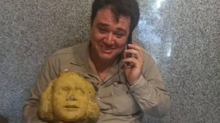 El hombre junto a la pieza de la escultura.
