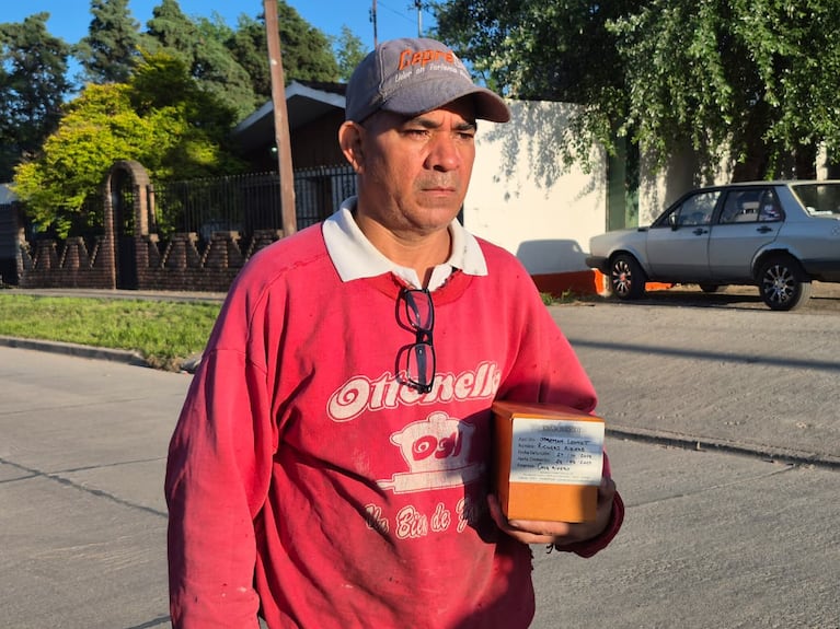 El hombre sostiene las cenizas de su hijo mientras espera Justicia. Foto: Juan Pablo Lavisse / El Doce.