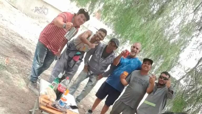 El jubilado y los obreros comiendo el asado.