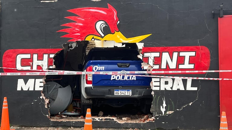 El móvil policial incrustado en un taller mecánico.