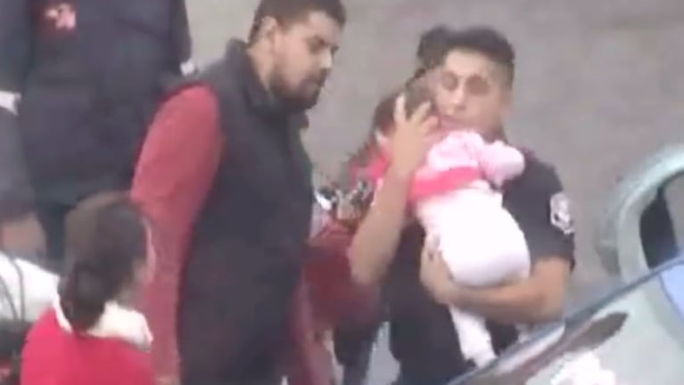 El policía tomo en brazos a la beba luego de salvarle la vida.