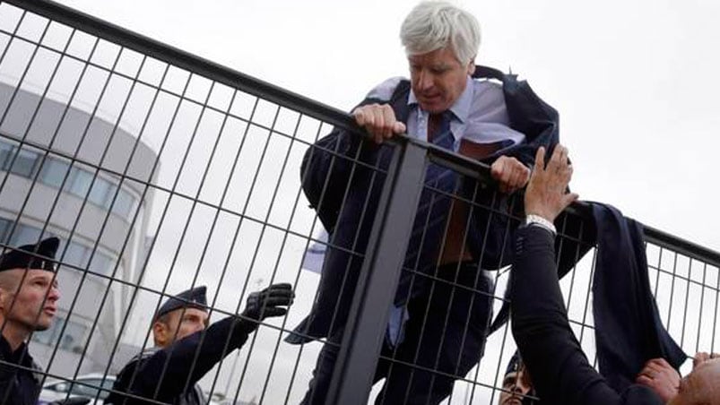 El presidente de la empresa, Frédéric Gagey, trepa una reja para que no lo atrapen los trabajadores que protestaban. Foto: AFP