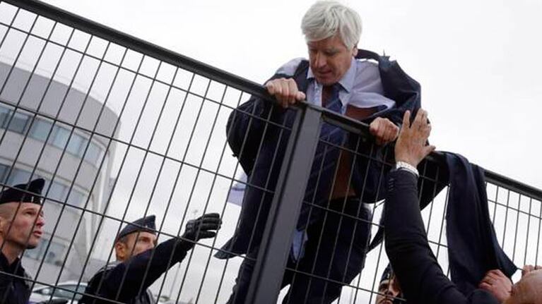 El presidente de la empresa, Frédéric Gagey, trepa una reja para que no lo atrapen los trabajadores que protestaban. Foto: AFP