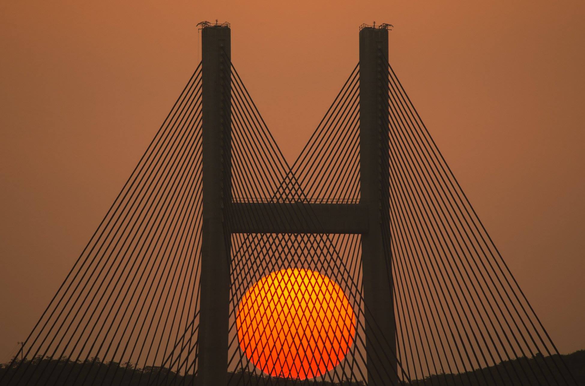 El sol detrás del puente en Sai Tso Wan, China. Foto: Eddy Chan.