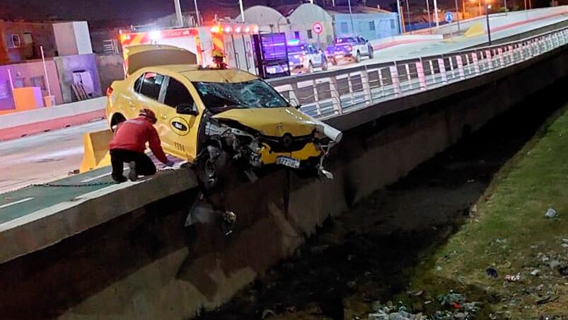 El taxi quedó colgado del puente tras el fuerte impacto contra la moto.