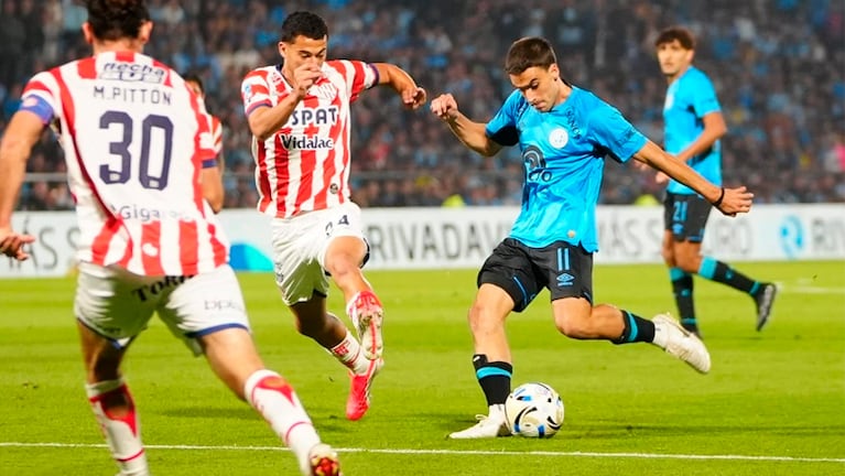 González Metilli busca sacar el remate ante la marca de dos futbolistas de Unión.