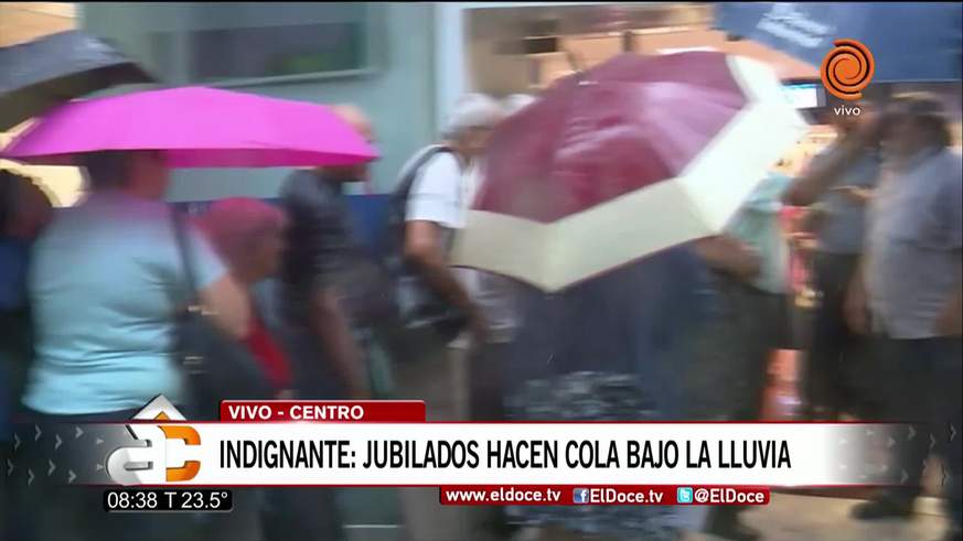 Jubilados cordobeses hacen cola bajo la lluvia para cobrar