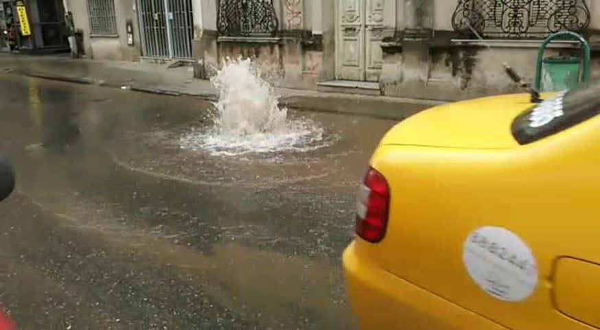 Calle inundada por un caño de agua roto