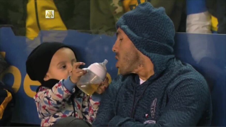Tevez tomando la mamadera de su hijo Lito