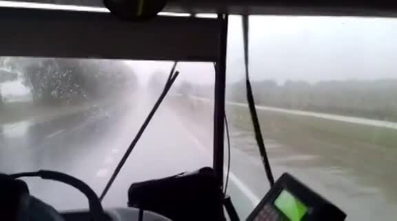 Un colectivo, sin limpiaparabrisas bajo la lluvia