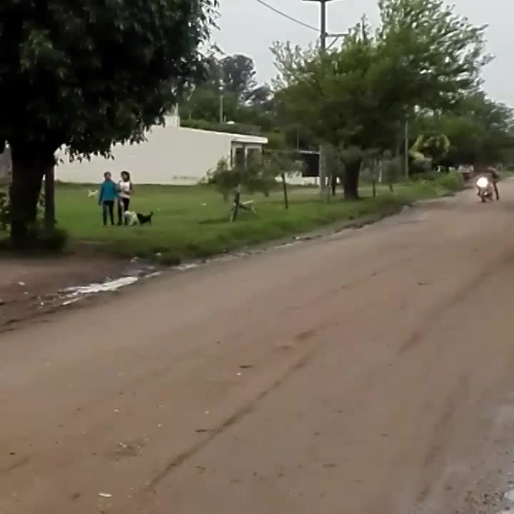 Una moto y una bici circulan atados de una soga