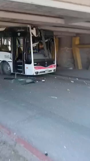 Un colectivo clavado contra un puente