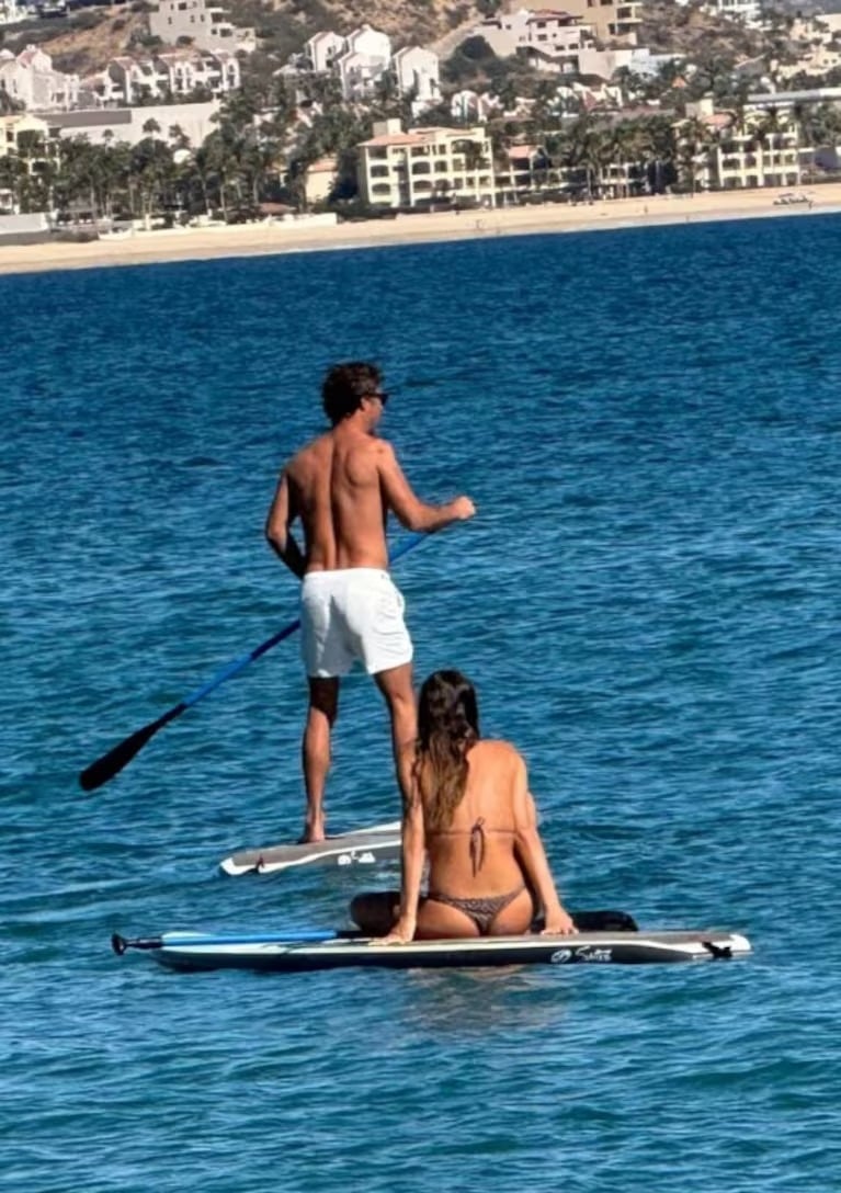 Imagen de las vacaciones juntas durante el último verano. Pampita mira embelesada a Martín Pepa hacer surf.