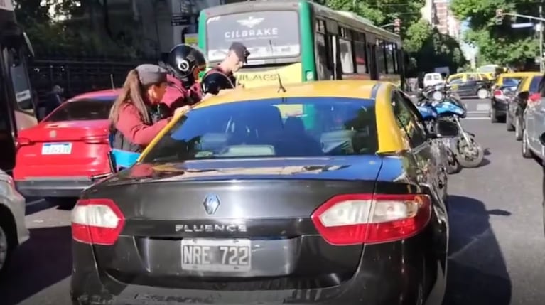 Insólito video: un taxista se quedó dormido en una avenida y tuvieron que “zarandear” el auto para despertarlo