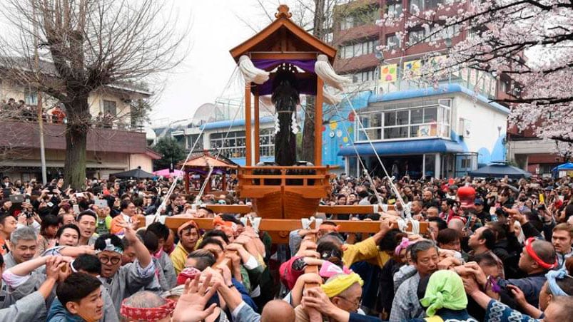 Japoneses llevando la escultura con el órgano masculino. 