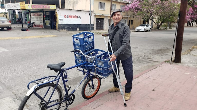 Juan junto a su bici adaptada con la que sale a repartir soda. Foto: Néstor Ghino / El Doce.
