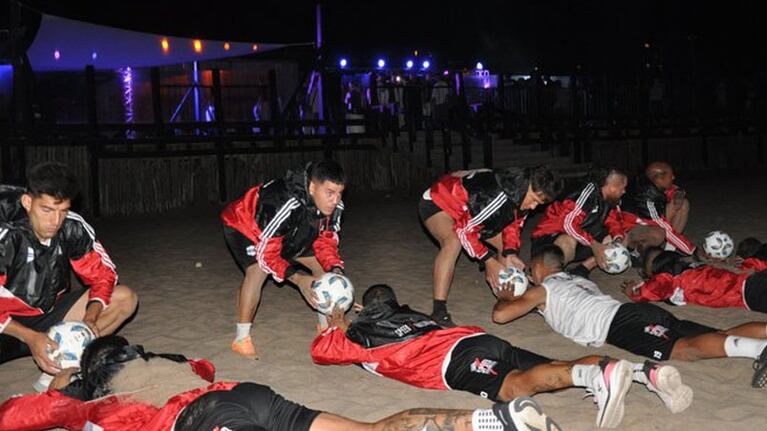 Jugadores entrenando con gente atrás bailando.