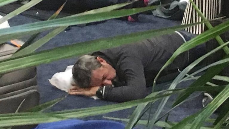 Julio Cobos durmiendo en el piso del aeropuerto.