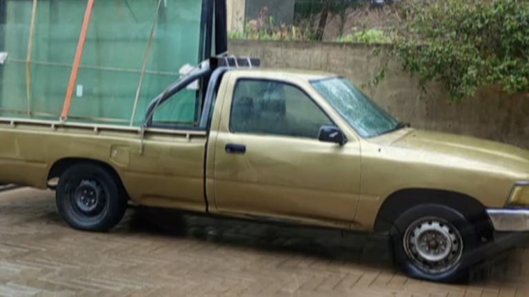 La camioneta es una Hilux dorada modelo 2001.