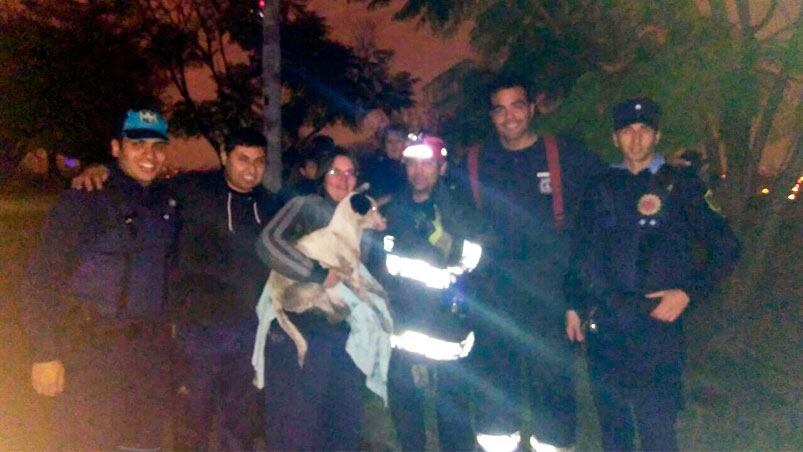 La dueña, los policías y los bomberos posando con Pirata. 