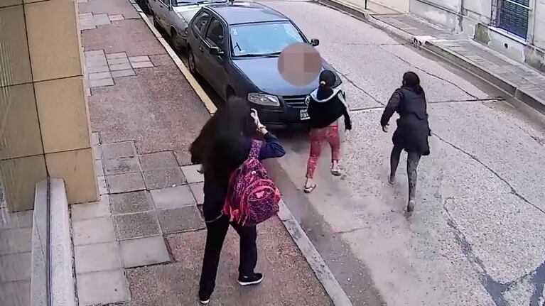 La mujer huye con el móvil y la menor corre a su lado.