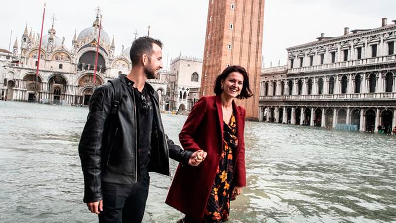 La pareja va romántica por las calles inundadas de Venecia.