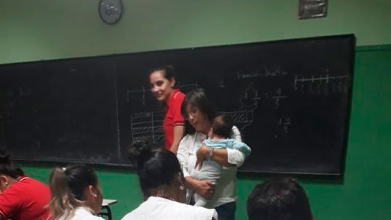 La profesora Gimena Pérez Puig tomó el bebé de su alumna en los brazos. 